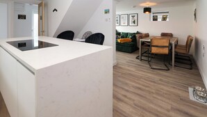 A modern kitchen with a white countertop and a built-in stove. - The Railway Cottage (Llandudno)