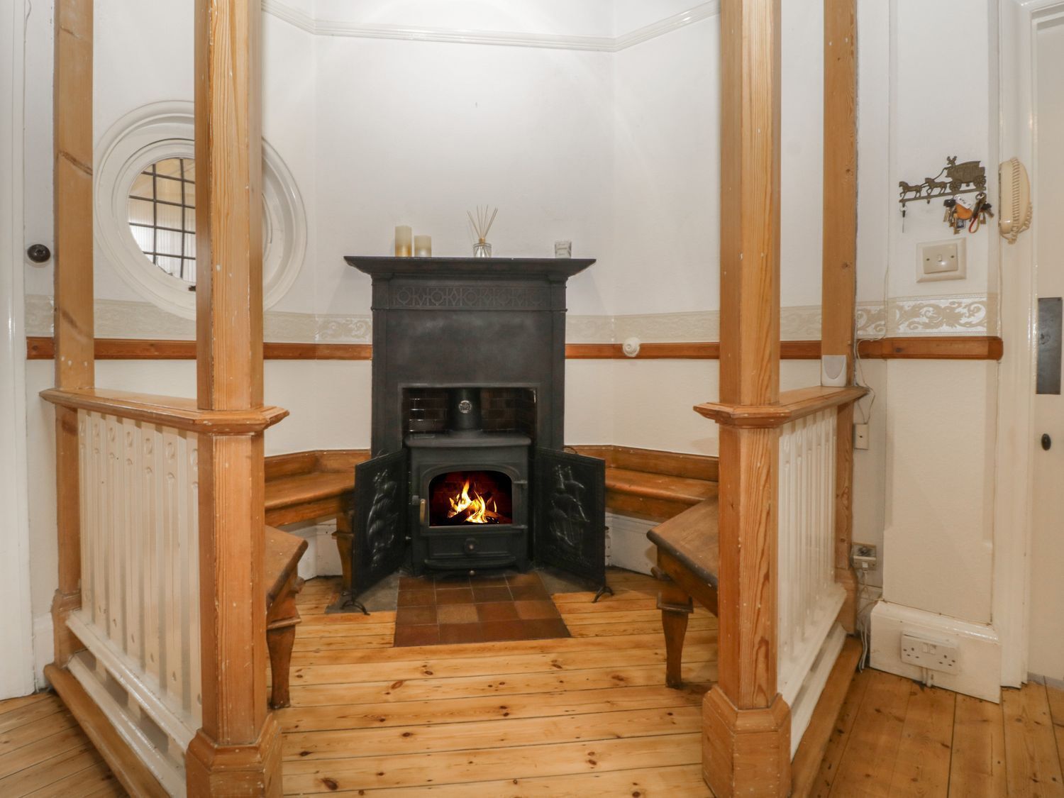 Ein Eckzimmer mit Kamin, Holzboden und Fenster.