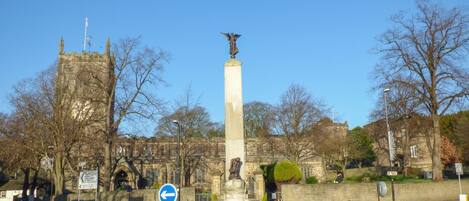 A roundabout with a central monument, a stone tower, and a clear blue sky.