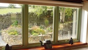 A window with a stone wall and a garden view.