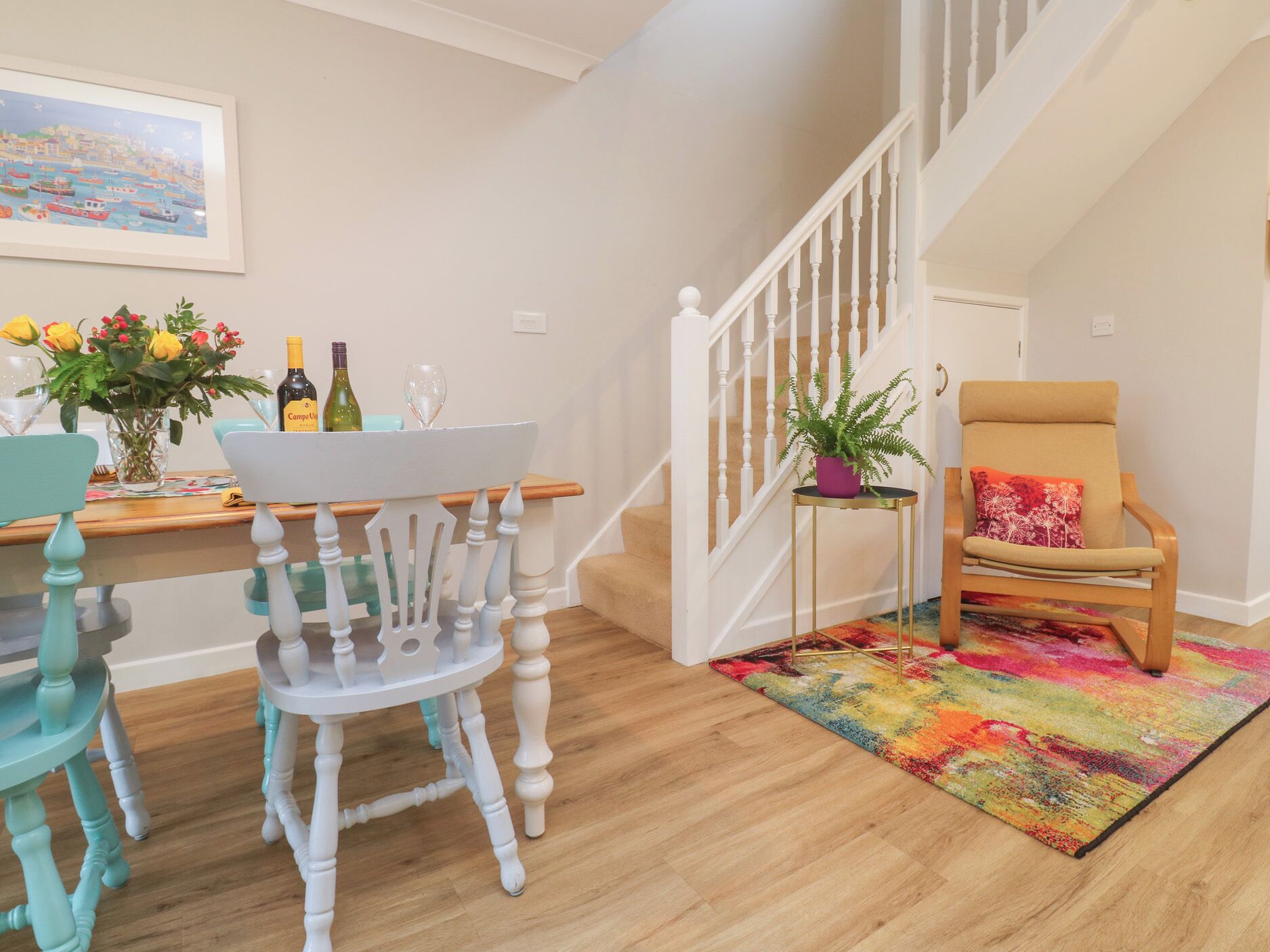 A dining area with a table, chairs, and a staircase.