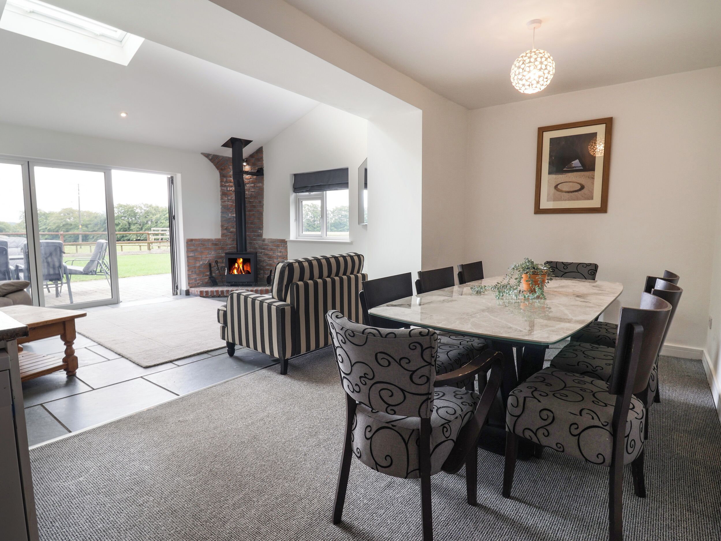 A modern living room with a fireplace, a dining table, and comfortable seating.