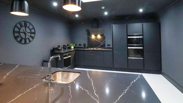 A modern kitchen with a marble countertop, stainless steel appliances, and pendant lighting. - Tower View (Scarborough)