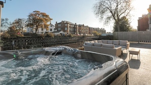 A hot tub with a view of residential buildings and a tree in the background. - Tower View (Scarborough)