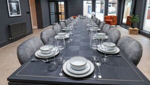 A conference room with a long table set for a meeting, equipped with plates, glasses, and cutlery. - Tower View (Scarborough)