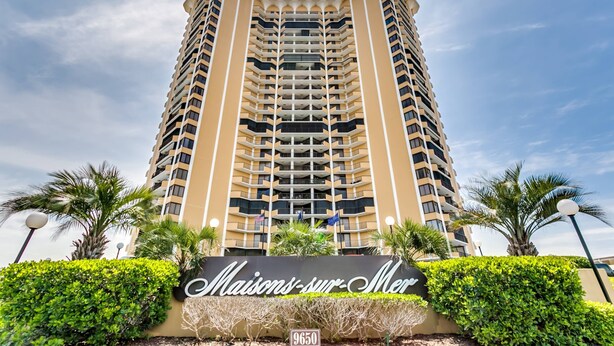 Un hotel alto con un letrero que dice "Maisons-sur-Mer" y el número "9650" debajo.