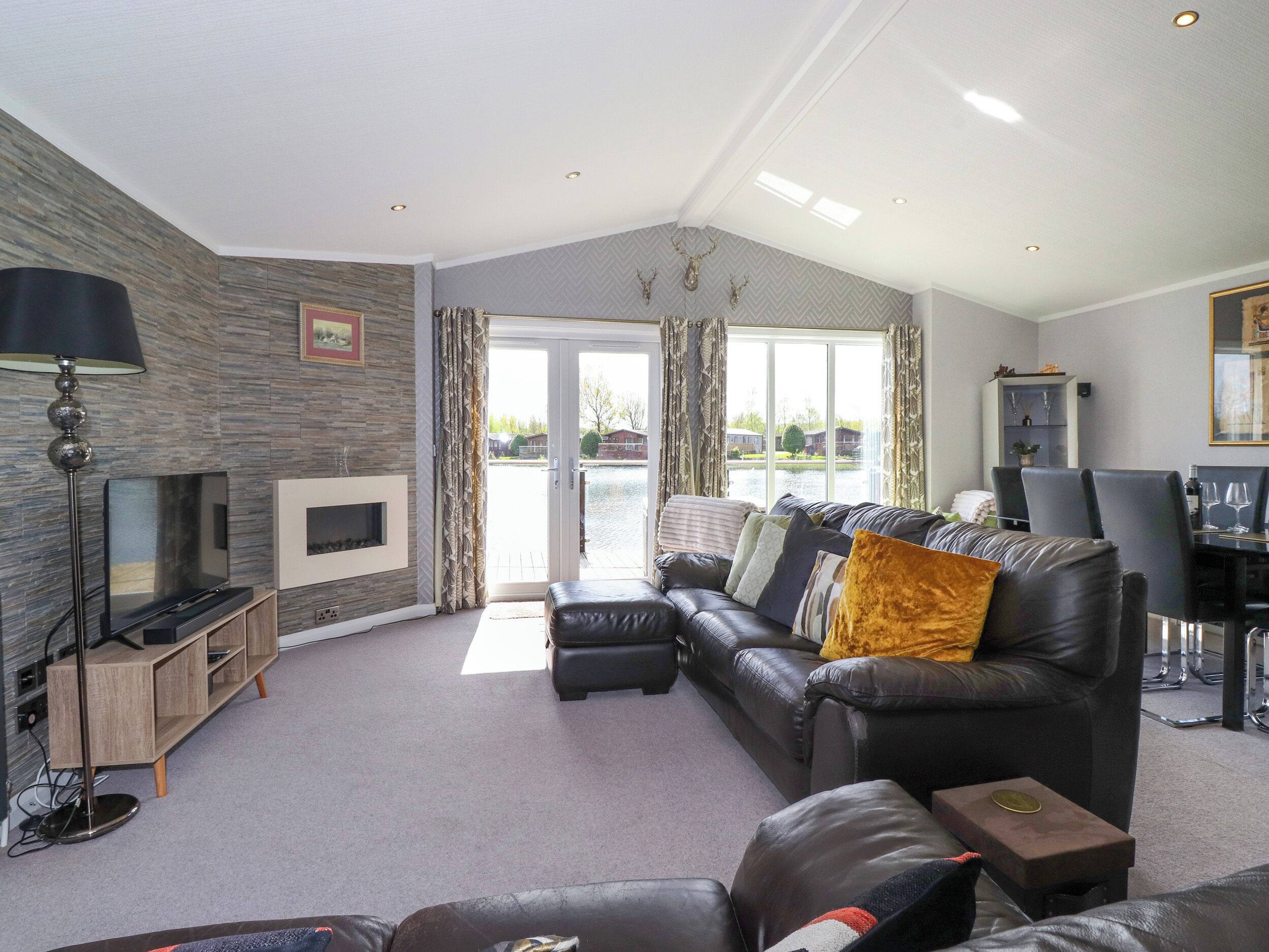 Egy modern nappali kandallóval, bőrkanapéval és étkezővel.