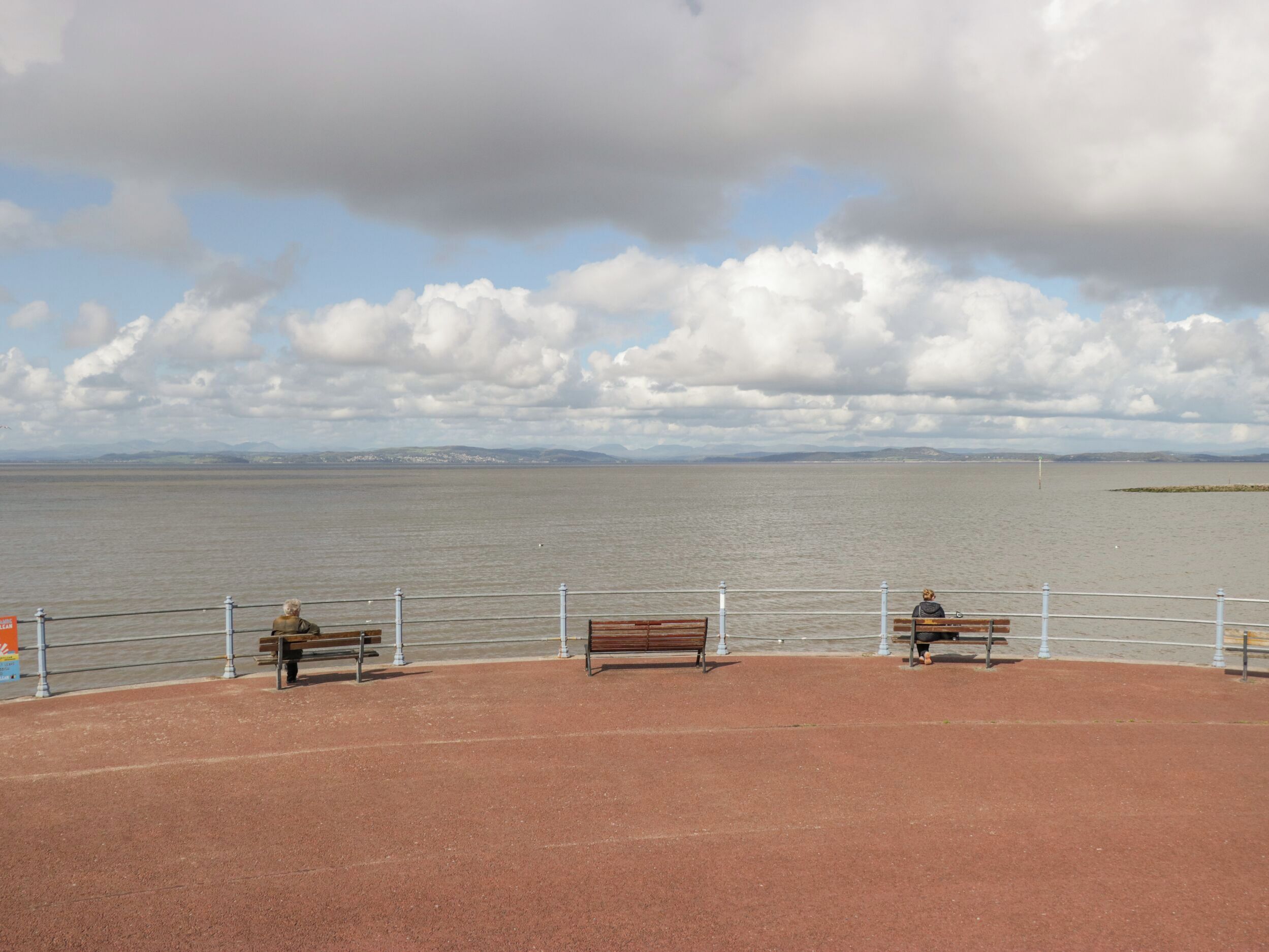 Eine Uferpromenade mit Bänken und einer Geländer.