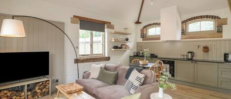 A cozy living room with a sofa, TV, and a fireplace.