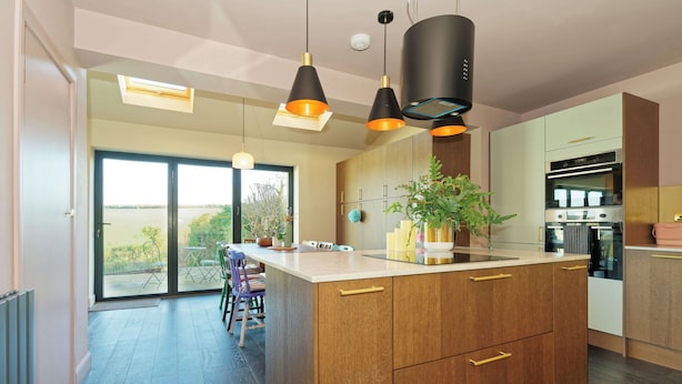 A modern kitchen with a central island, pendant lighting, and a view to the outdoors. - Kent Downs Cottage (Canterbury)