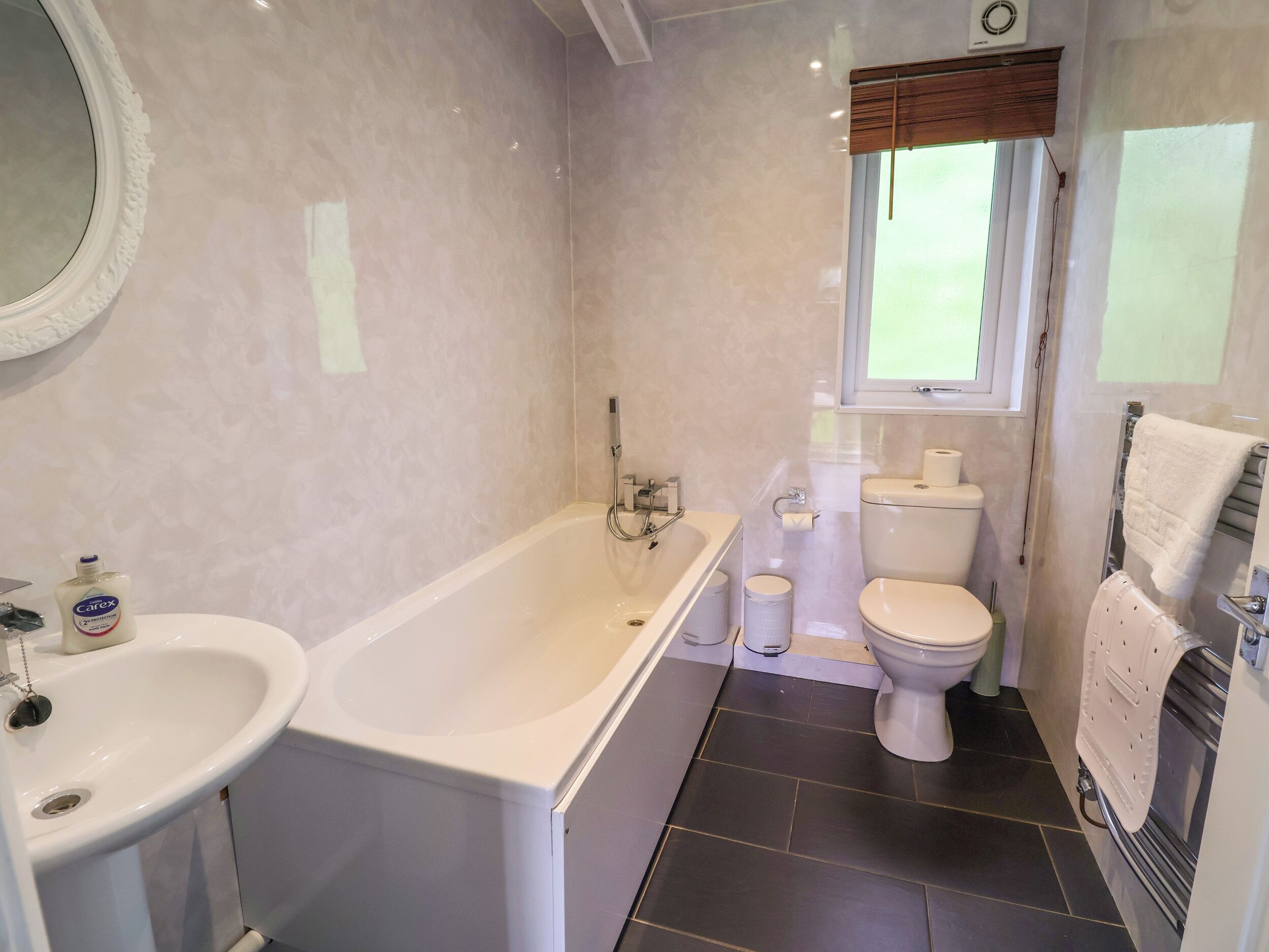 A modern bathroom with a bathtub, toilet, and sink.