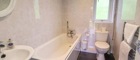 A modern bathroom with a bathtub, toilet, and sink.