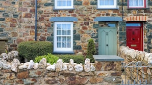 A stone building with two windows and a door. - Orielton Cottage (Newport)