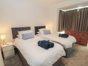 A hotel room with two beds, a nightstand, a dresser, and a lamp. - The Swanage Rail Lookout (Swanage)