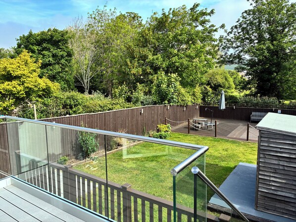 A backyard with a wooden deck, a glass railing, and a fenced area. - The Swanage Rail Lookout (Swanage)