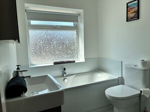A bathroom with a window, a sink, a toilet, and a towel. - The Swanage Rail Lookout (Swanage)