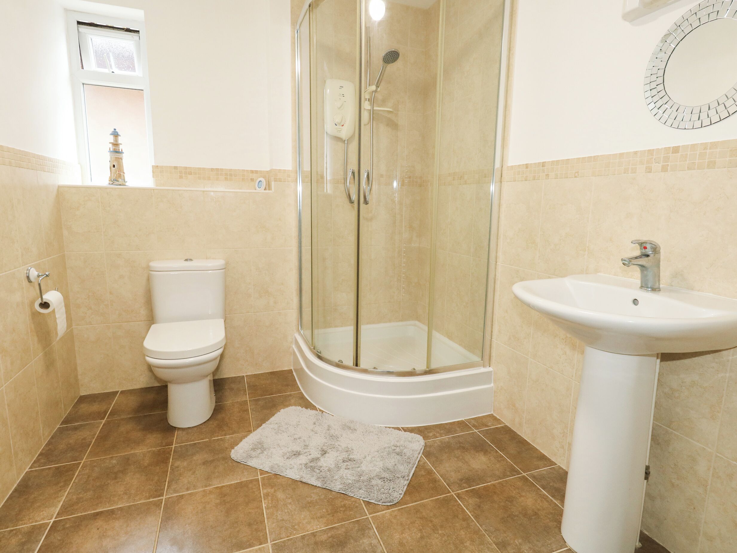 A bathroom with a toilet, a glass-enclosed shower, and a sink.