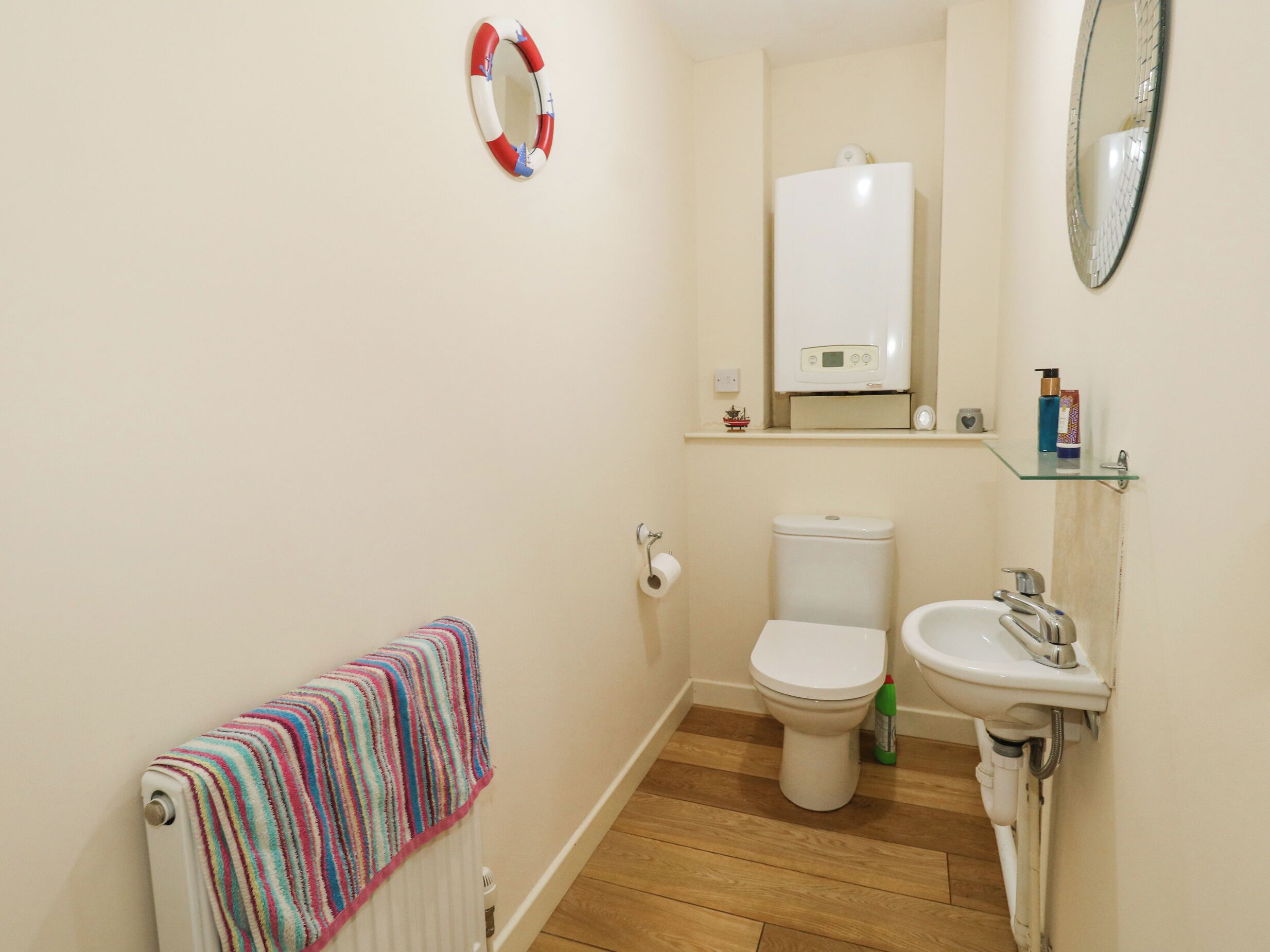 Un baño con inodoro, lavamanos y toallero.