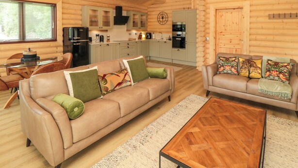 L’intérieur d’une cabane en rondins comprend un salon, une cuisine et un coin repas.