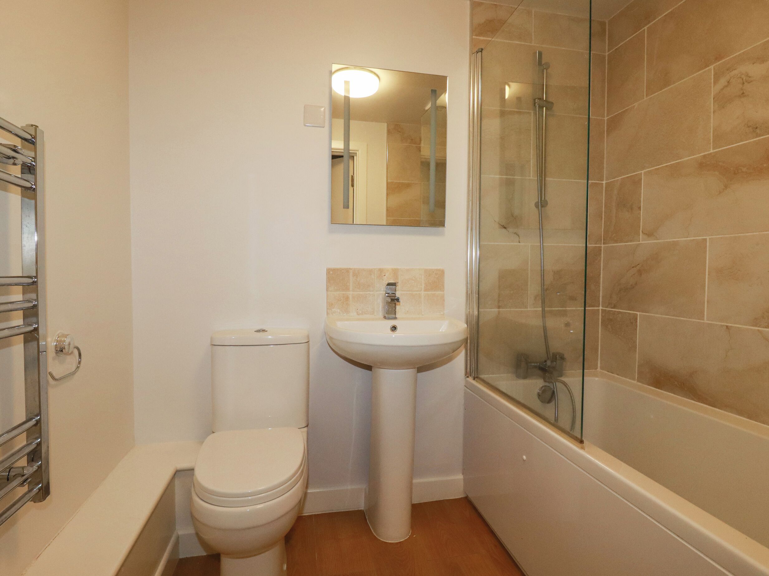 A bathroom with a toilet, sink, and glass-enclosed shower.