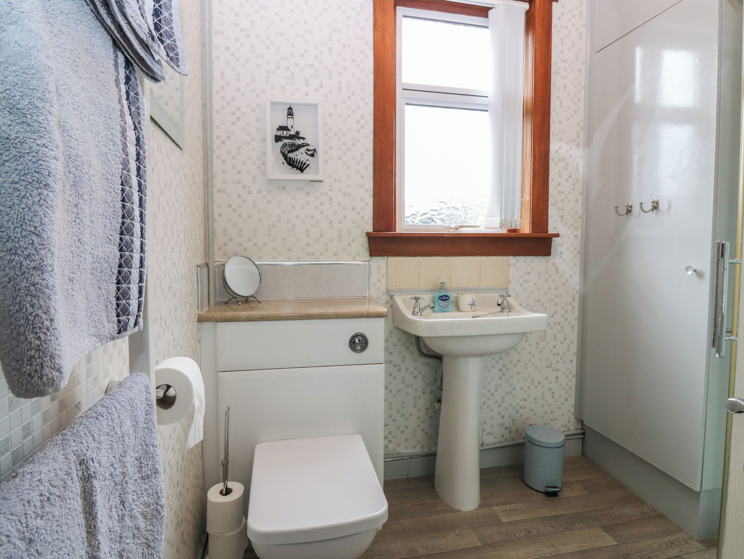Un baño con inodoro, lavamanos y espejo.