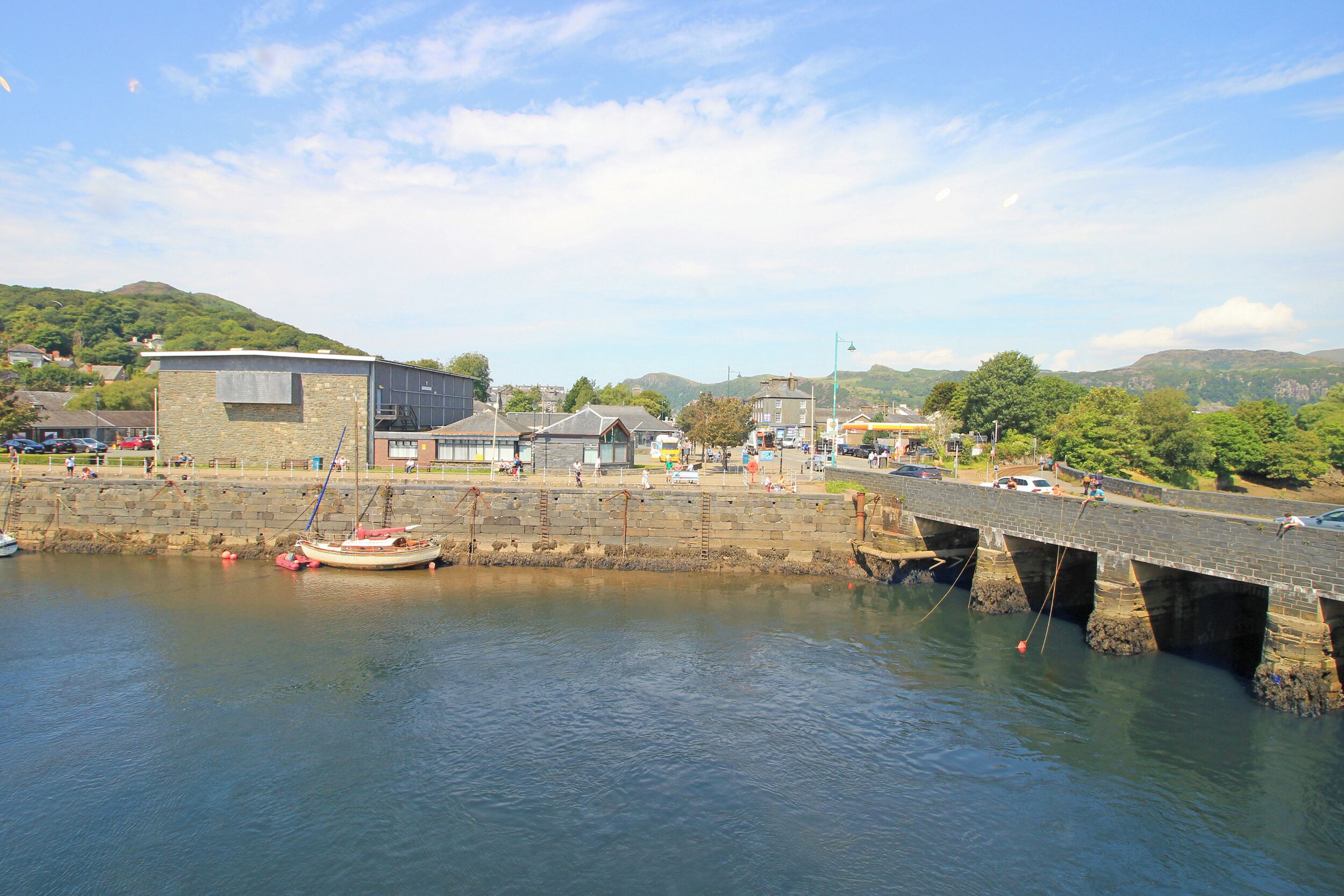 A waterfront area with a bridge, boats, and buildings.