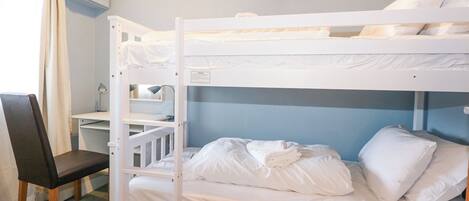 Une chambre avec un lit superposé, un bureau et une chaise, une fenêtre avec des rideaux et un plafond en bois.