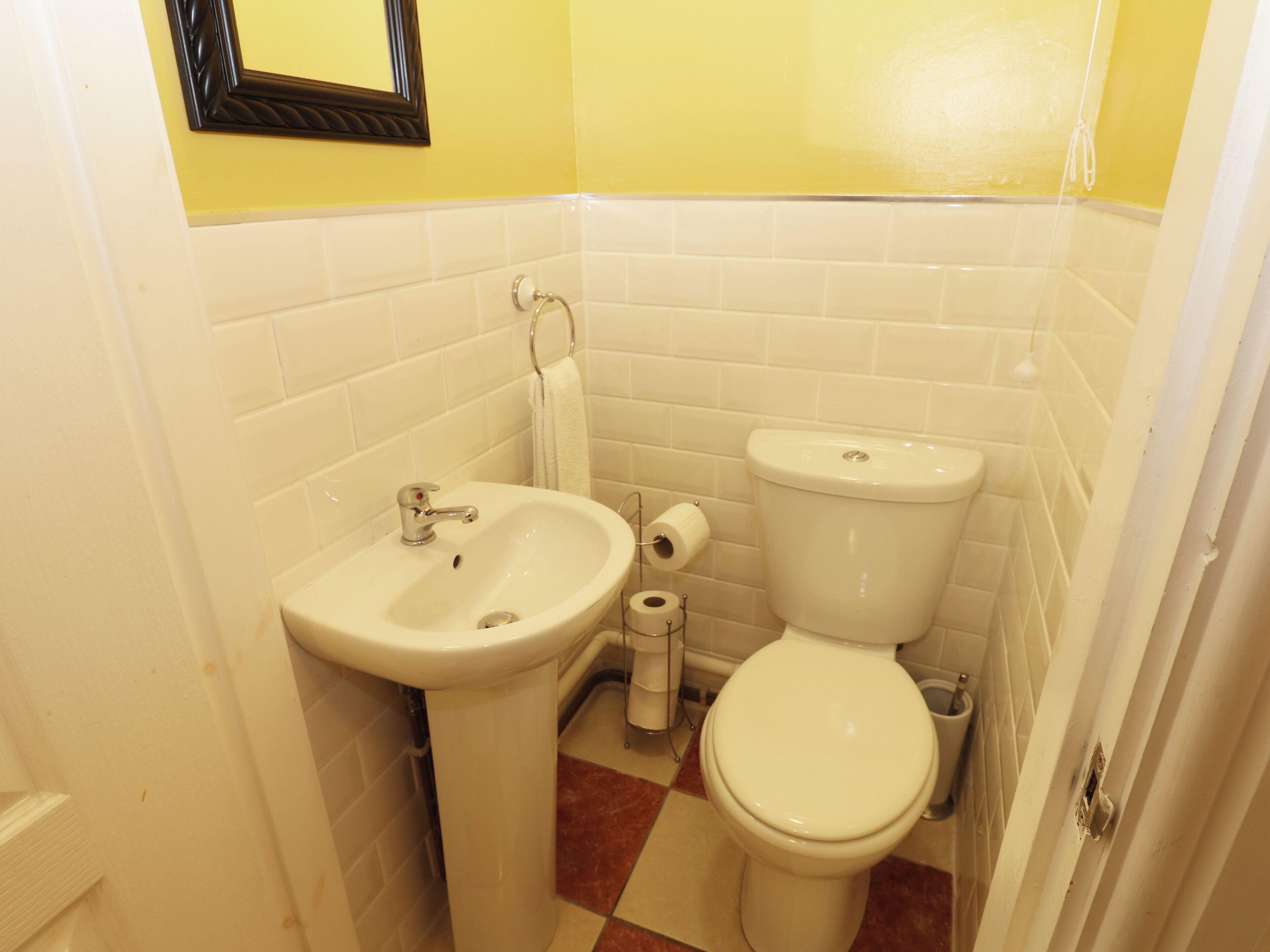 Une petite salle de bain avec un lavabo, des toilettes et un miroir au mur.