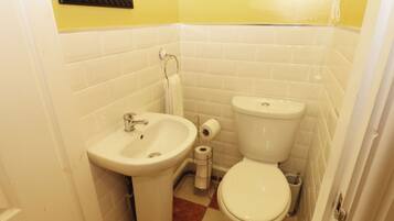 Une petite salle de bain avec un lavabo, des toilettes et un miroir au mur.
