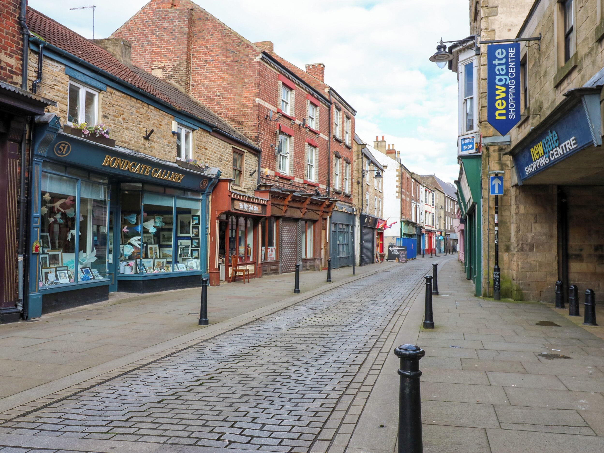 Une rue pavée bordée d’immeubles en briques, dont la galerie Bondgate et le centre commercial Newgate.
