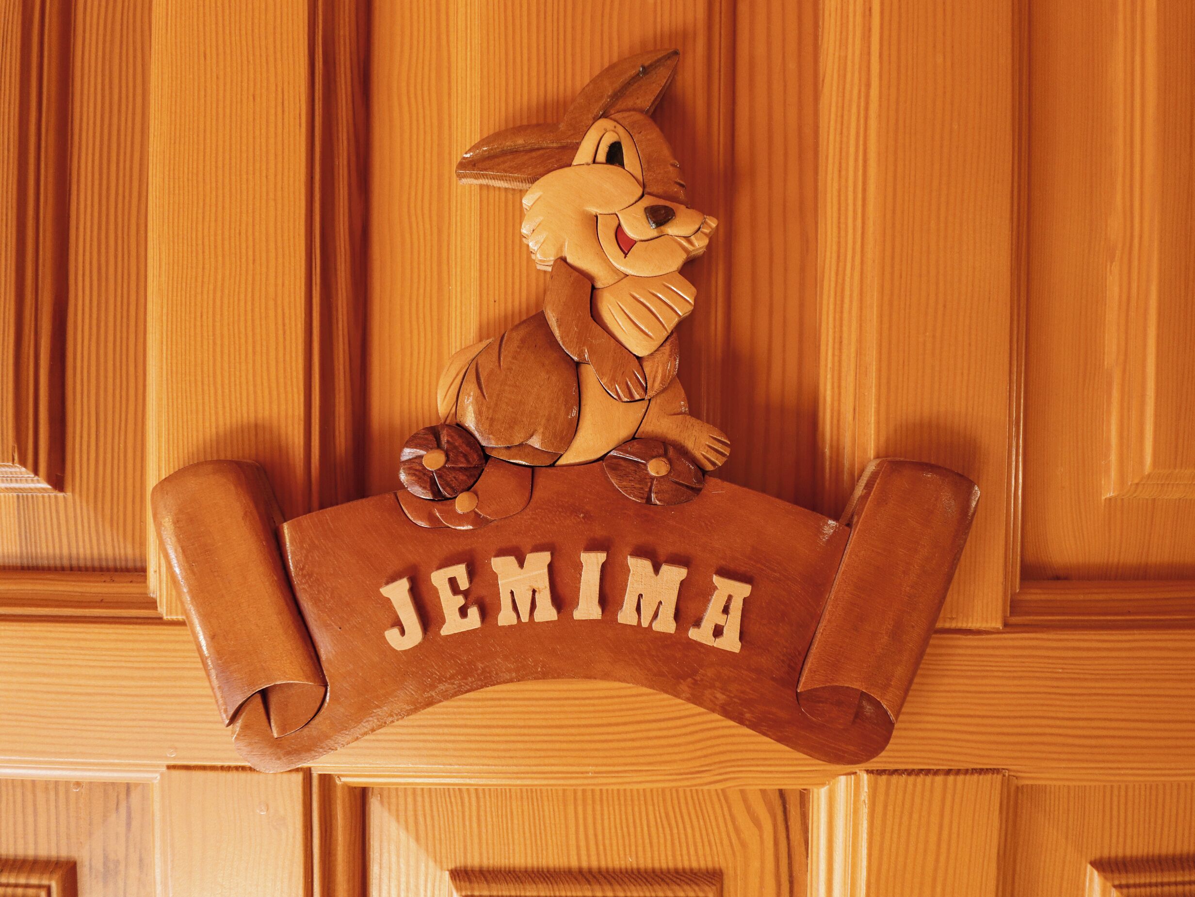 Un letrero de madera con un personaje de conejo y el nombre 'JEMIMA' grabado.