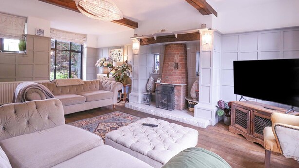 Una sala de estar acogedora con chimenea, asientos cómodos y un televisor.