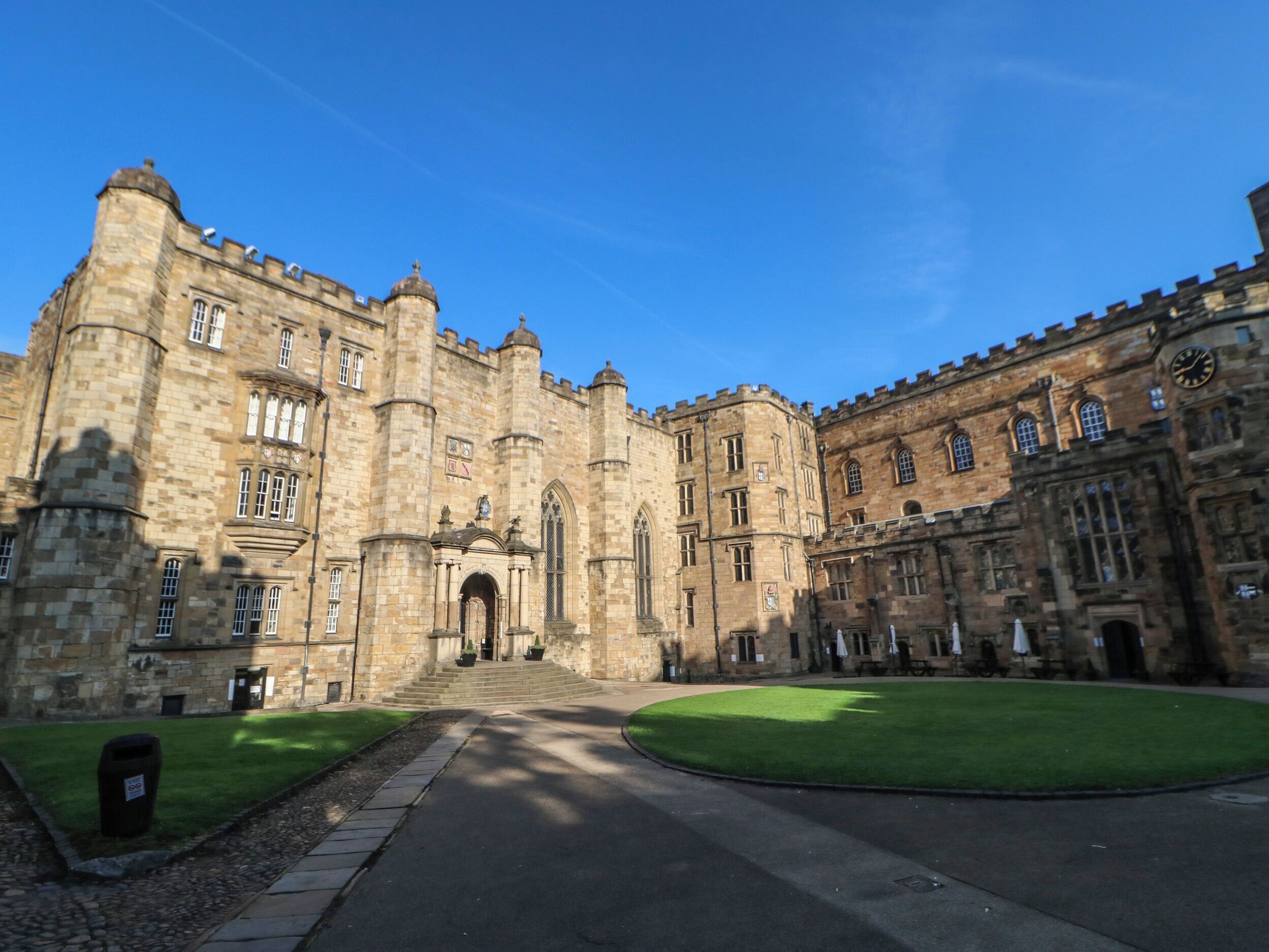 A historic stone building with a central entrance, large windows, and a symmetrical facade.