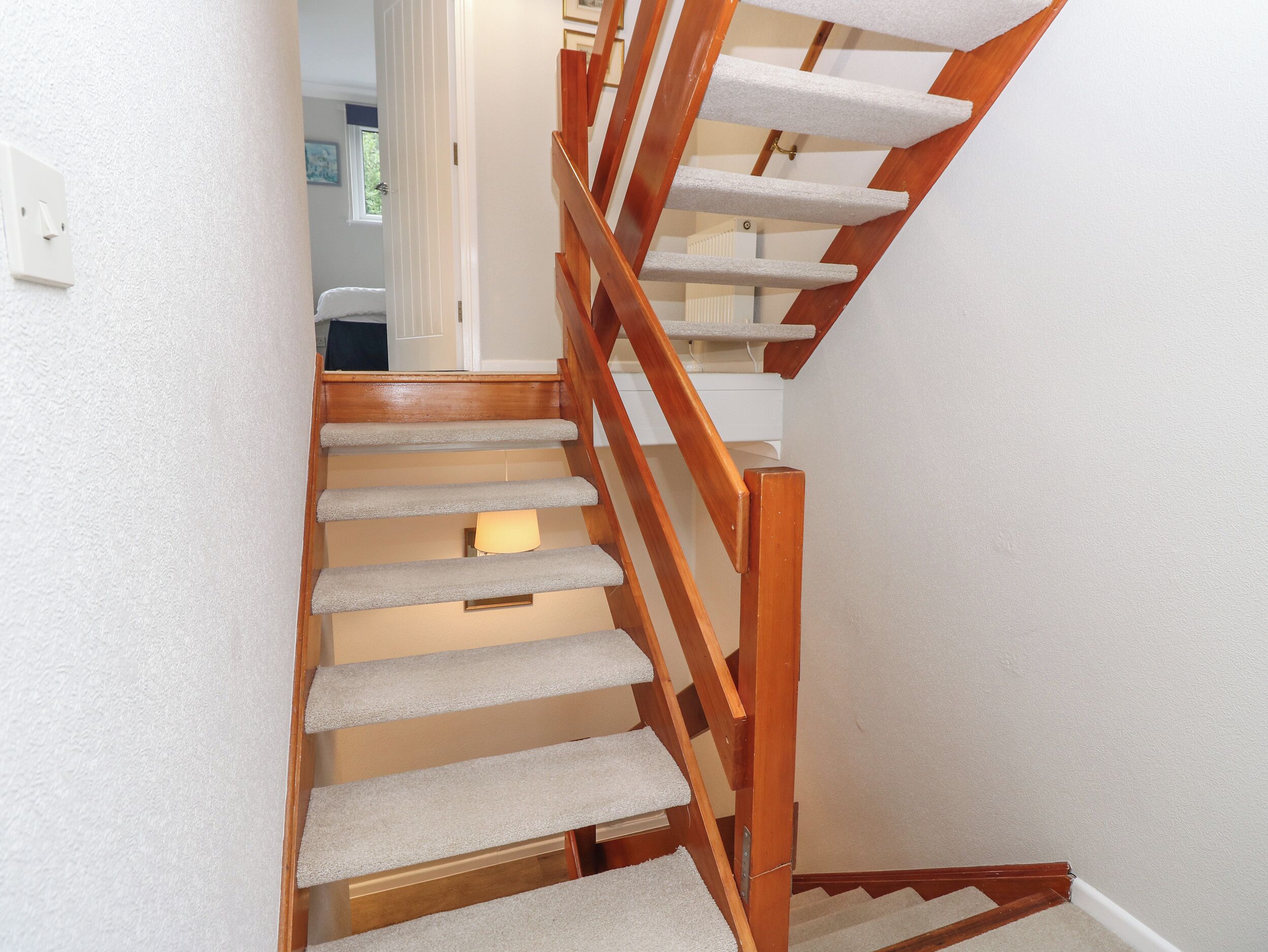 A wooden staircase with carpeted steps leading to a landing.