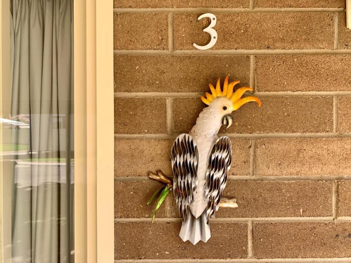 A bird-shaped decoration on a brick wall with the number '3' above it.