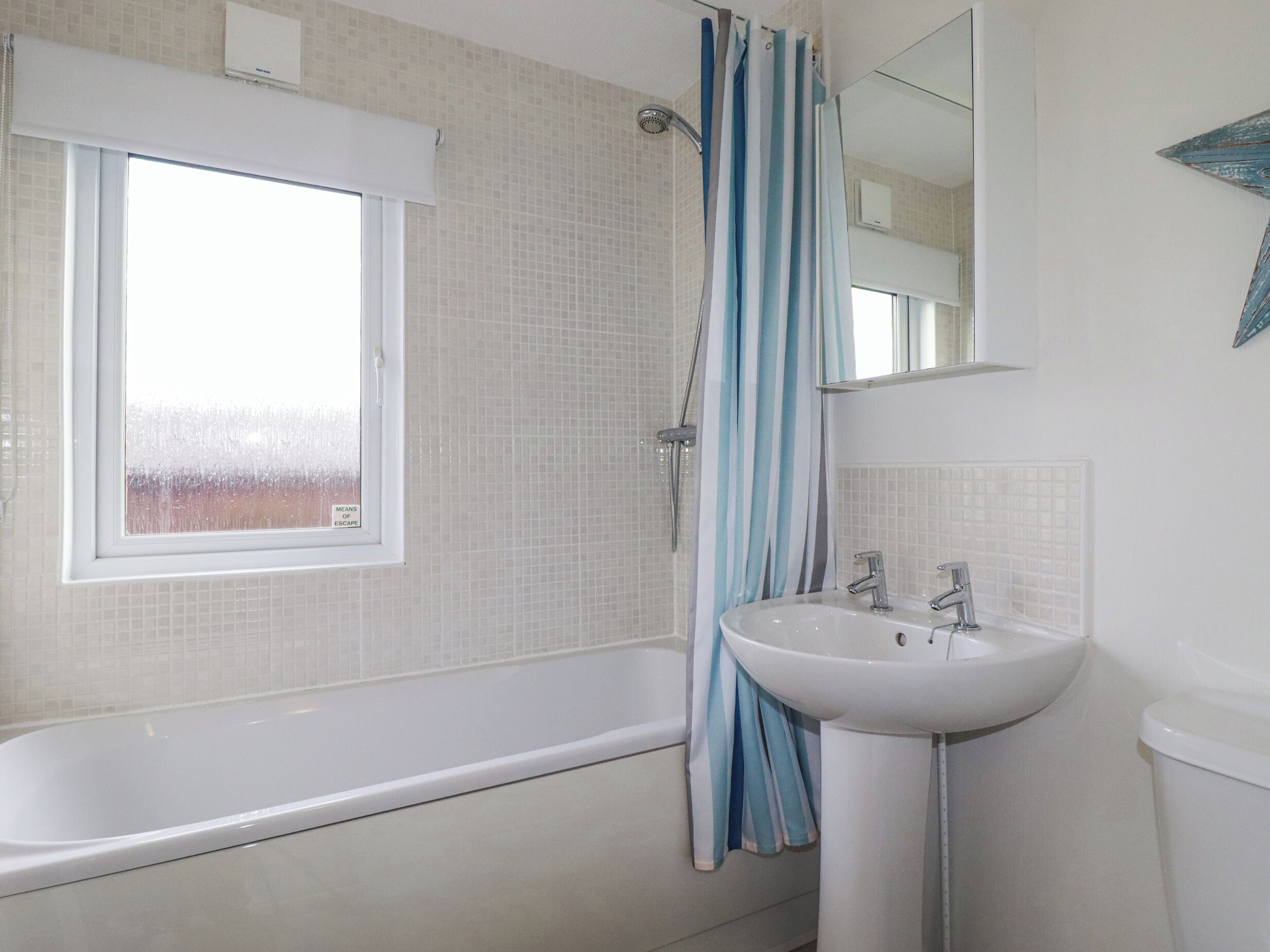 A bathroom with a bathtub, a sink, and a window.