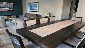 A dining area with a long table, chairs, and a ceiling fan. - 4-bedroom house in delightful Glendale with WiFi, fitness room, AC (Glendale)