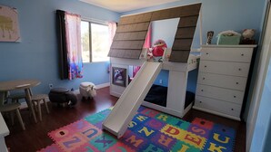 A child's playroom with a slide, alphabet foam mats, and a window with curtains. - 4-bedroom house in delightful Glendale with WiFi, fitness room, AC (Glendale)