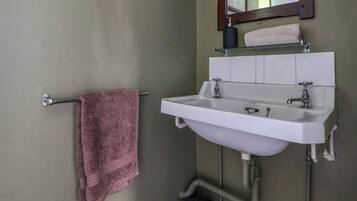 A bathroom with a white sink, a mirror, and a towel rack.