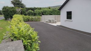 A modern building with a paved patio, a picnic table, and a small window. - Mountain View (Limavady)