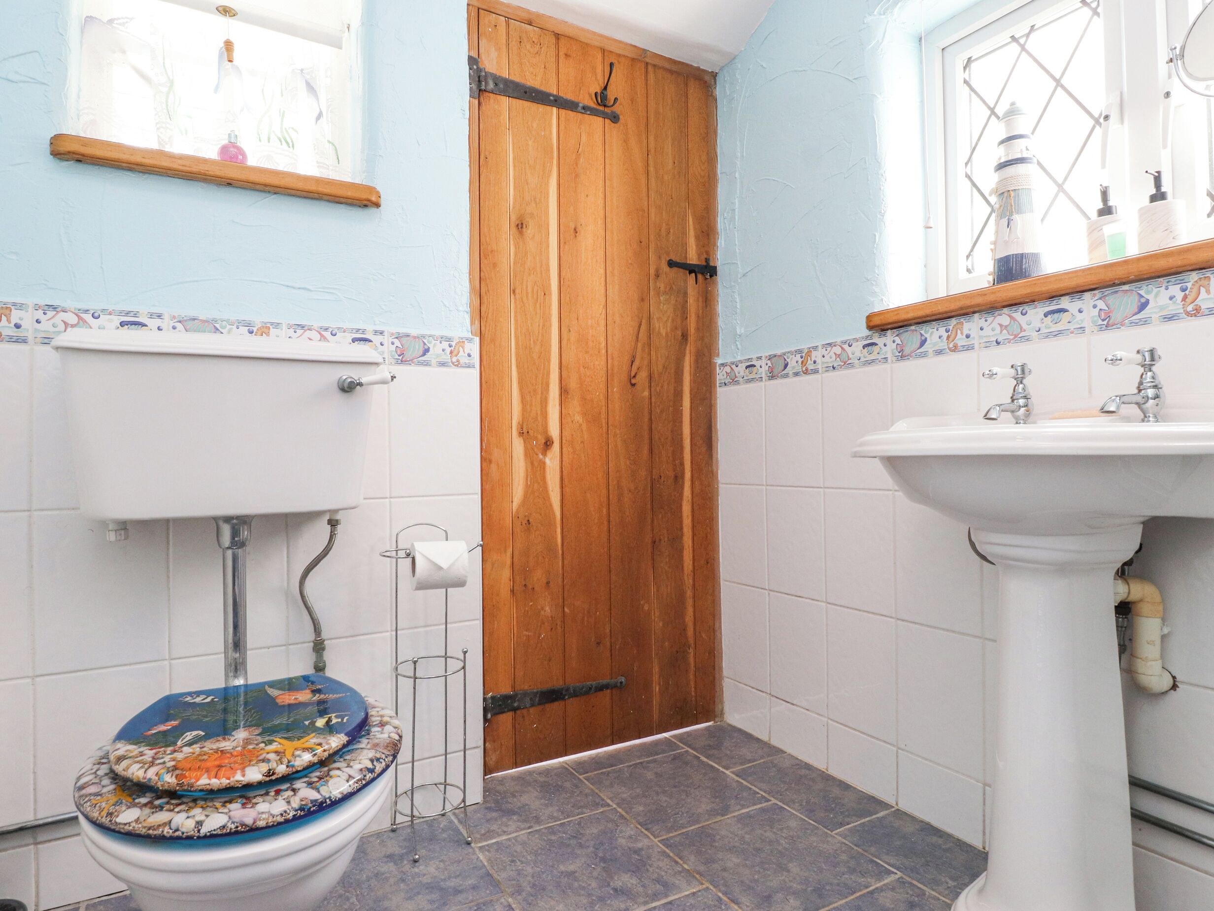 A bathroom with a toilet, sink, and wooden door.