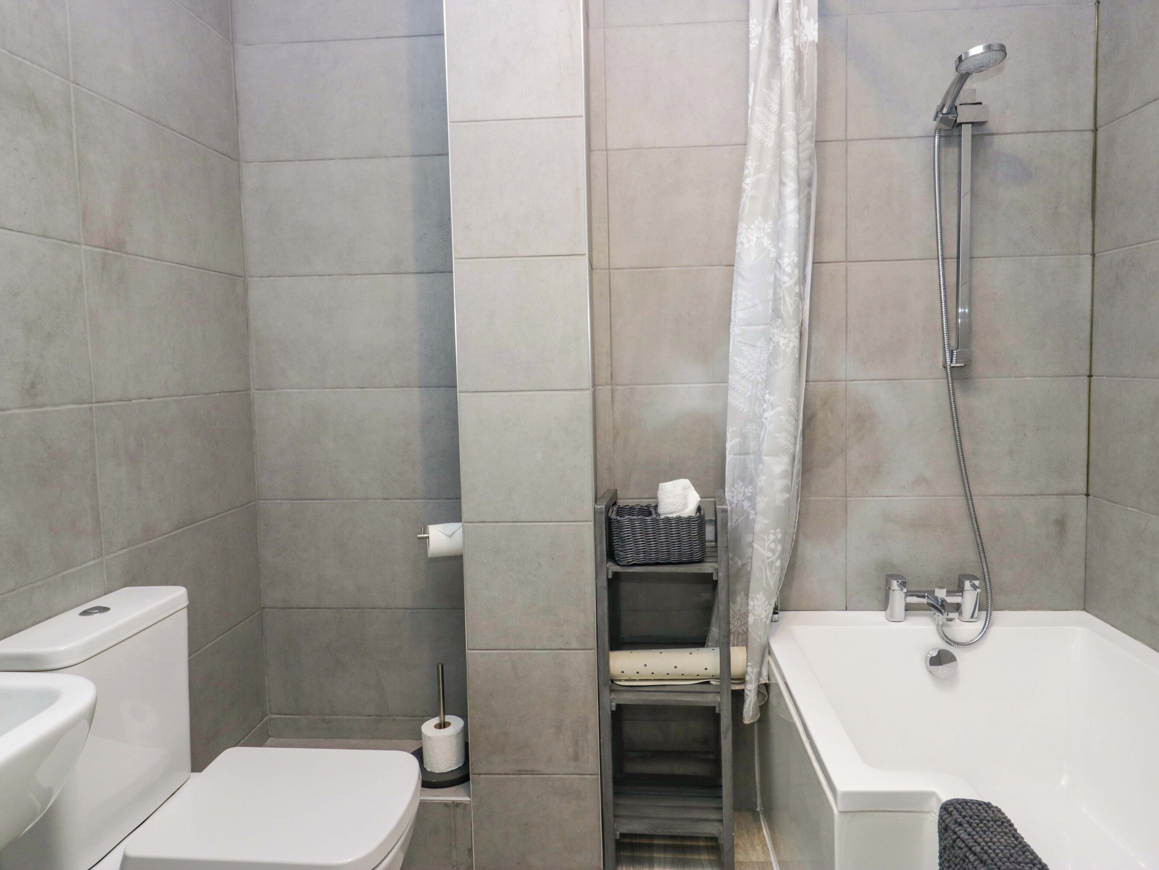 A bathroom with a toilet, a shower, and a bathtub.