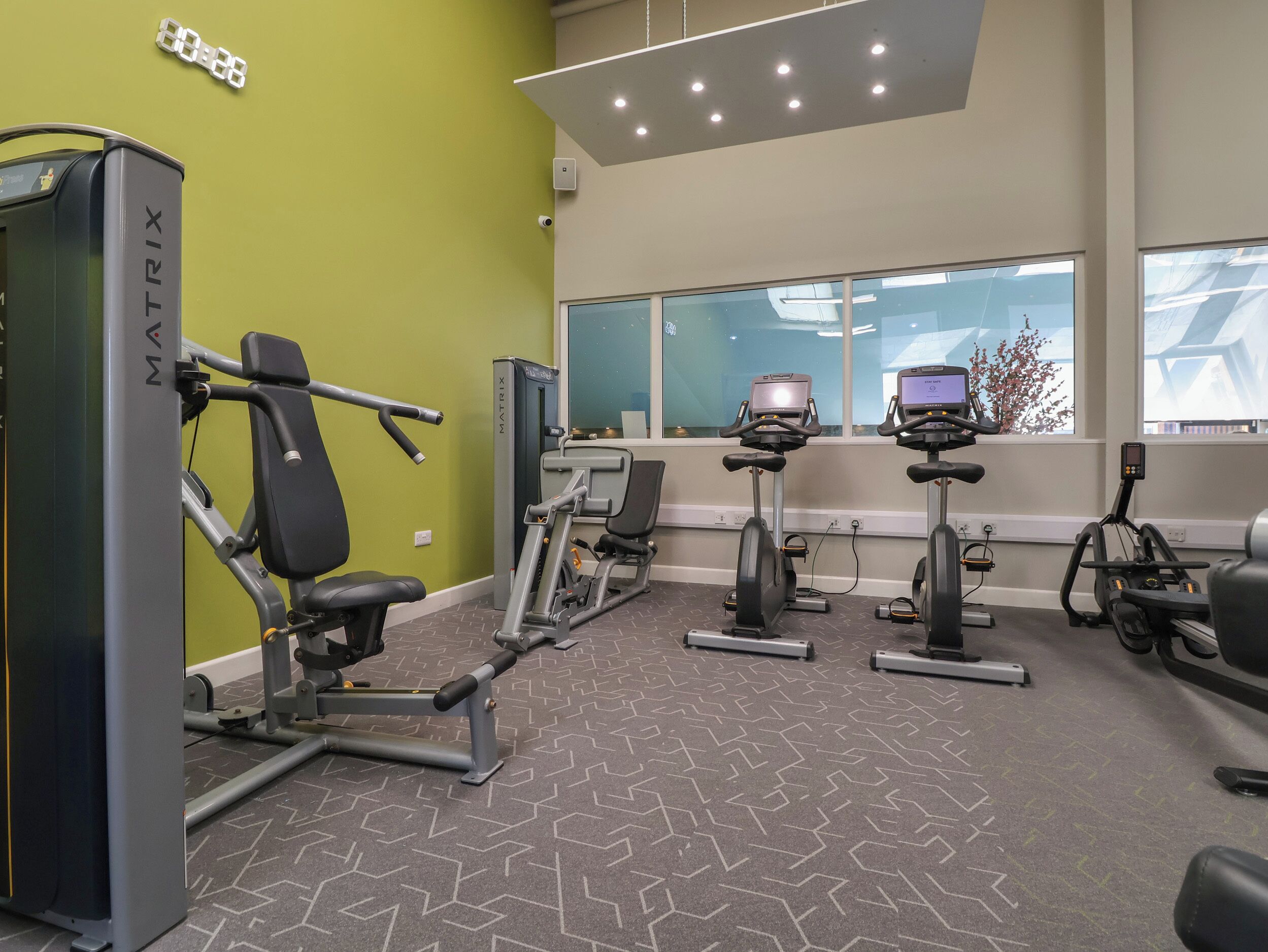 A gym with cardio equipment, weight machines, and a Matrix branded squat rack.