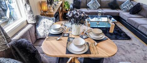 A cozy dining area with a round table set for four, surrounded by comfortable seating.