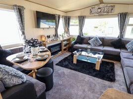 A cozy living room with a sofa, a coffee table, and a TV.
