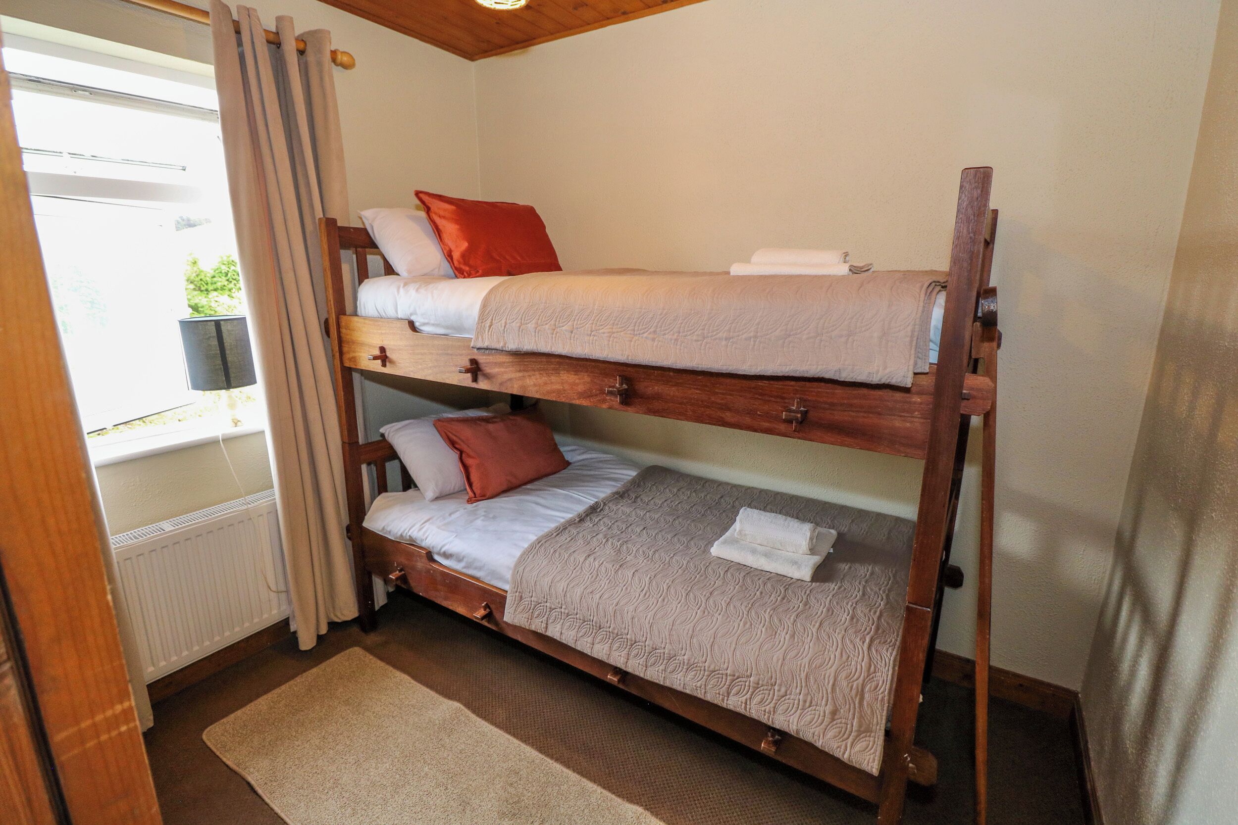 A bunk bed with two levels, each with pillows and a blanket.