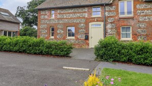 A two-story brick building with a beige door, a small porch, and a sign reading "CAFF COTTAGE." - 8 Rookhaye (Salisbury)