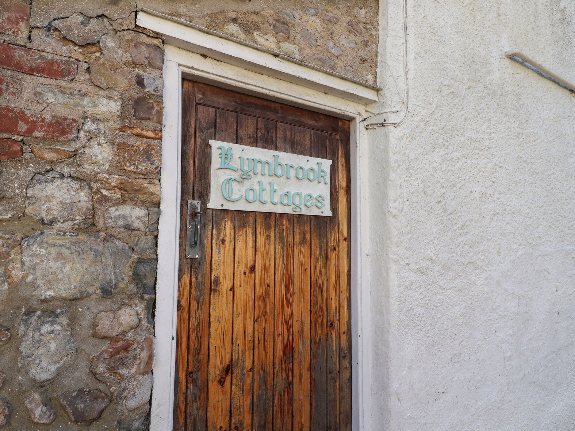 A wooden door with a sign that reads "Lyndbrook Cottages."