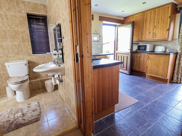 Une salle de bain comprenant des toilettes, un lavabo et un espace douche.