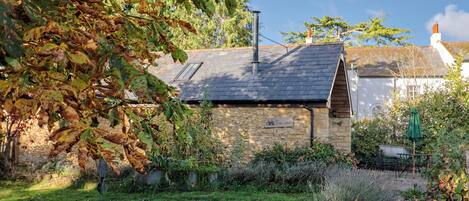 A stone building with a sloped roof, a chimney, and a sign that reads 'CART SHED'.